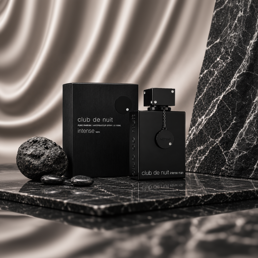 Club de Nuit Intense Man perfume bottle and its black packaging box, styled on a dark marble surface with smooth stones against a satin gold fabric backdrop.